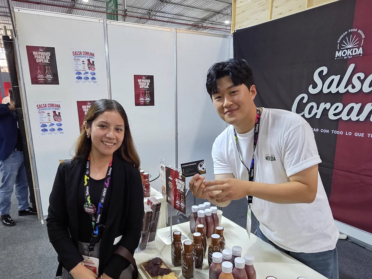 Gyeom Park with a visitor and sauces at the MOKDA booth at Expoalimentaria 2026